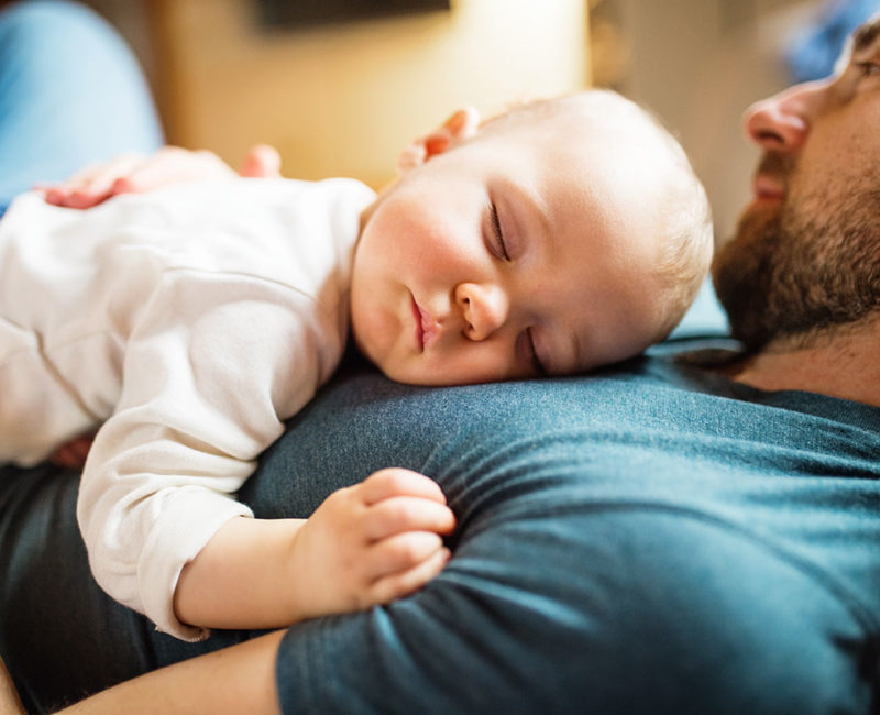 baby sleeps on father's chest