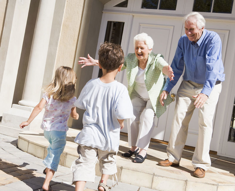 children run into arms of grandparents outside home