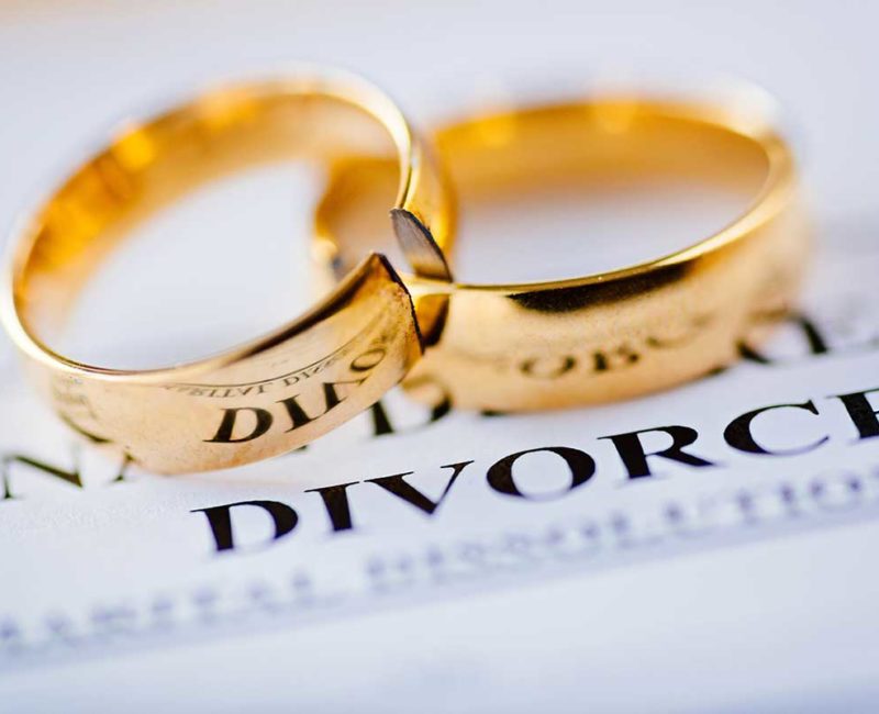 wedding rings on top of divorce papers