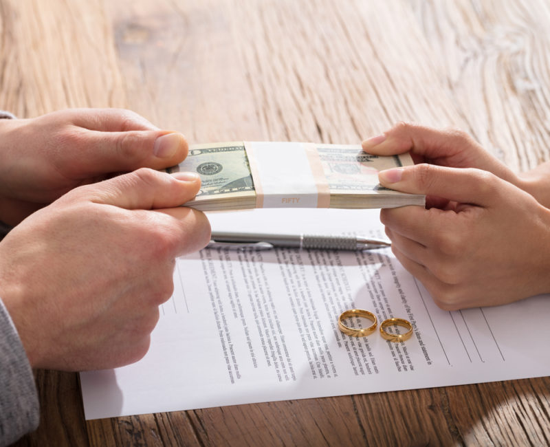 Couple fighting over money near divorce papers