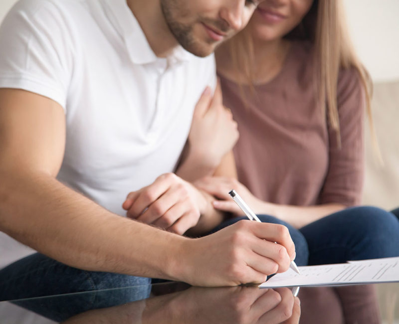 Man and woman who are soon to be married signing a prenup