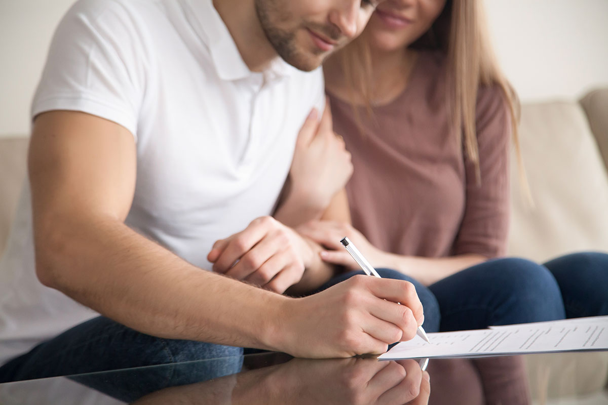 Man and woman who are soon to be married signing a prenup