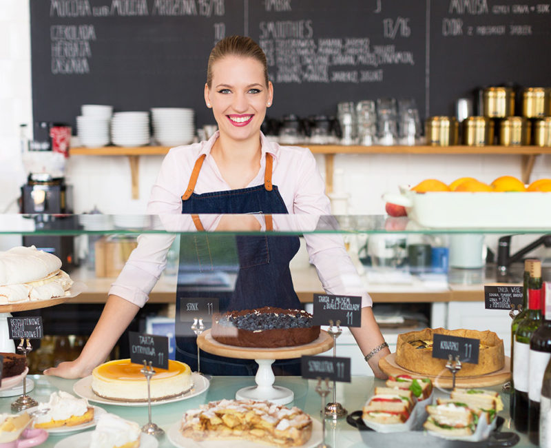 Woman standing behind a dessert counter